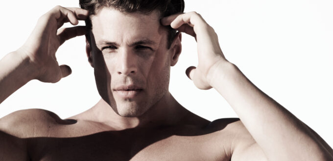 Man posing with bare, waxed, muscular chest